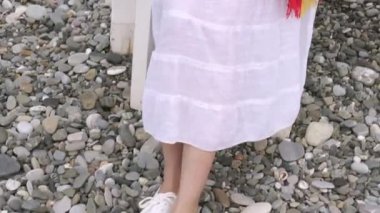 Sahilde parlak battaniye sarılmış Pretty kadın sahilde bir karton cam dan kahve içiyor, deniz veya okyanus yanında