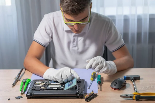 Homem está reparando um laptop usando ferramentas — Fotografia de Stock