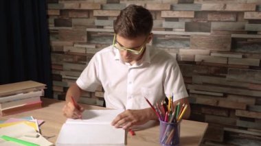 Genç çocuk bir not defteri veya copybook bir kalp çizer. Genç bir kağıt yırtıp yiyor. Gençlerin sorunları ve karşılıksız aşk