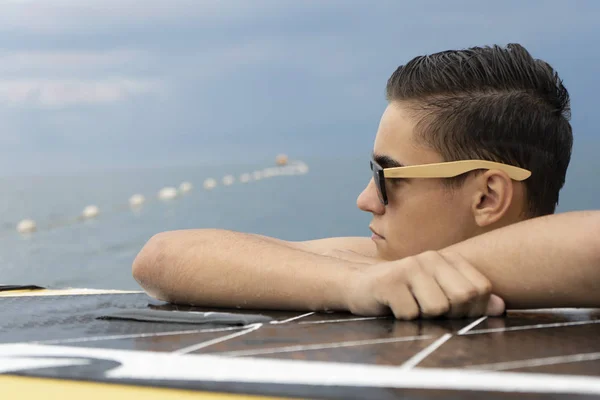 Bello ragazzo surfista in cerca delle onde sul tramonto — Foto Stock