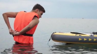 Can yeleği acemi sörfçü sakin su üzerinde sup sörf öğrenmek için hazırlanıyor. Sup sörfçüleri can yeleği giyer. Su rekreasyon güvenliği