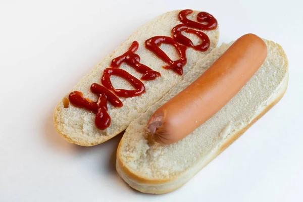 Hot dog zsemle főtt sertés kolbásszal fehér alapon. Írj ketchupos hot-dogot kenyéren. Első látásra. Közelkép — Stock Fotó