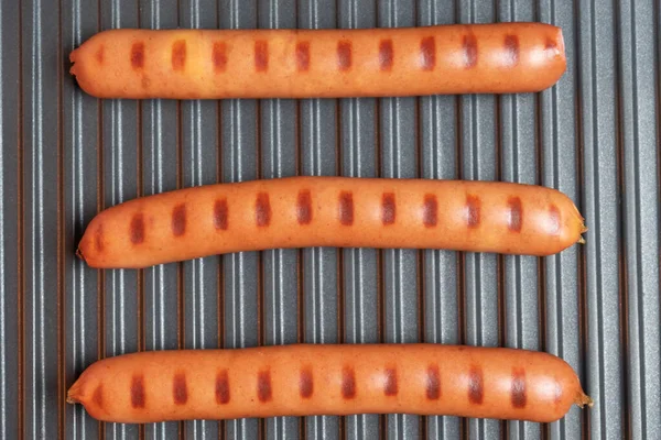 Három Bratwurst kolbász az elektromos grillezőn. Hagyományos német étel. Bbq. — Stock Fotó