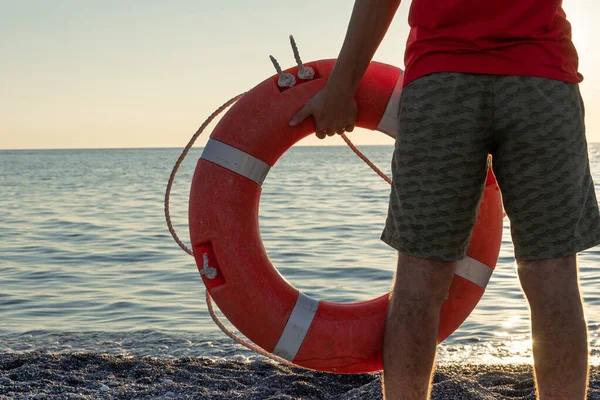 Bagnino in servizio. Un giovanotto con una boa di salvataggio. Sicurezza in acqua — Foto Stock