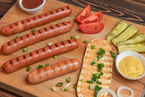 Homemade fried sausages, bread and vegetables on the desk — Stock Photo, Image