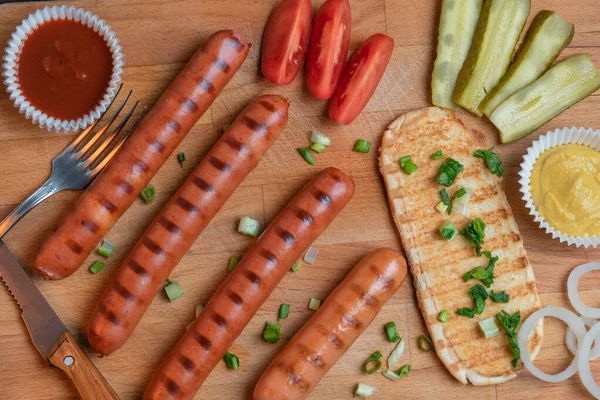 Домашній обід з смаженими ковбасками, хлібом та овочами на столі — стокове фото
