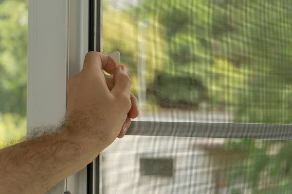 Böceklerden korunma. İnsanın eli geri çekilebilir pil ekran tutucusu pencereyi açmak ya da kapatmak için seçici olarak ele odaklanır