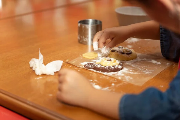 The kid prepares a cake in the shape of a bear at a cooking class for kids