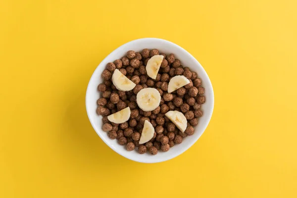 Weiße Schüssel Voll Mit Müslibällchen Aus Schokolade Und Bananenscheiben Auf — Stockfoto