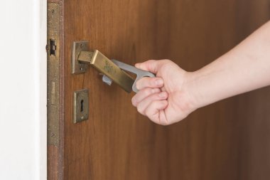 Genç adam, Coronavirus hastalığının yayılmasını önlemek için, kapı açmak için temas kurulamayan bir araç kullanıyor, Covid-19. Yeni normal.