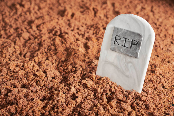 Halloween party fun food: sugar tombstone buried in chocolate cake ground, copy space
