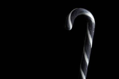 Siyah zemin üzerinde siyah beyaz çizgili Cadılar Bayramı bastonu ve fotokopi alanı