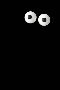 Cadılar Bayramı arka planı, koyu siyah arka planda bir çift beyaz göz, kopyalama alanı.