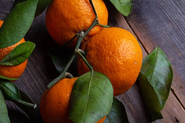 tangerines with leaves on pine boards