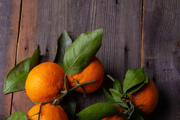 tangerines with leaves on pine boards