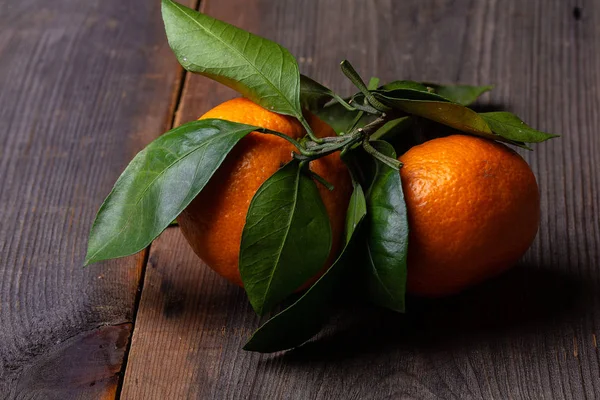 tangerines with leaves on pine boards