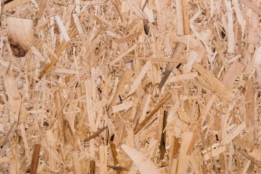 OSB tahtaları ahşap bir zemine zımparalanmış kahverengi odun parçalarından yapılmıştır. OSB ahşap kaplama arka planının üst görüntüsü, sıkı, pürüzsüz yüzey. Oryantasyon Strand Kurulu. Süpürge tahtası. Sterling tahtası. Aspenite