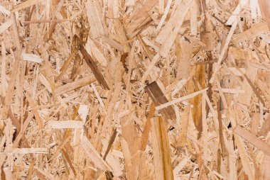 OSB tahtaları ahşap bir zemine zımparalanmış kahverengi odun parçalarından yapılmıştır. OSB ahşap kaplama arka planının üst görüntüsü, sıkı, pürüzsüz yüzey. Oryantasyon Strand Kurulu. Süpürge tahtası. Sterling tahtası. Aspenite