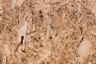 OSB tahtaları ahşap bir zemine zımparalanmış kahverengi odun parçalarından yapılmıştır. OSB ahşap kaplama arka planının üst görüntüsü, sıkı, pürüzsüz yüzey. Oryantasyon Strand Kurulu. Süpürge tahtası. Sterling tahtası. Aspenite