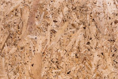 OSB tahtaları ahşap bir zemine zımparalanmış kahverengi odun parçalarından yapılmıştır. OSB ahşap kaplama arka planının üst görüntüsü, sıkı, pürüzsüz yüzey. Oryantasyon Strand Kurulu. Süpürge tahtası. Sterling tahtası. Aspenite