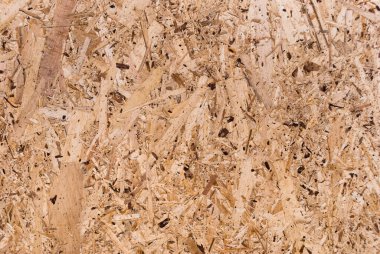 OSB tahtaları ahşap bir zemine zımparalanmış kahverengi odun parçalarından yapılmıştır. OSB ahşap kaplama arka planının üst görüntüsü, sıkı, pürüzsüz yüzey. Oryantasyon Strand Kurulu. Süpürge tahtası. Sterling tahtası. Aspenite