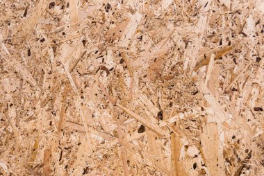 OSB tahtaları ahşap bir zemine zımparalanmış kahverengi odun parçalarından yapılmıştır. OSB ahşap kaplama arka planının üst görüntüsü, sıkı, pürüzsüz yüzey. Oryantasyon Strand Kurulu. Süpürge tahtası. Sterling tahtası. Aspenite