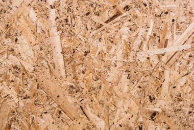 OSB tahtaları ahşap bir zemine zımparalanmış kahverengi odun parçalarından yapılmıştır. OSB ahşap kaplama arka planının üst görüntüsü, sıkı, pürüzsüz yüzey. Oryantasyon Strand Kurulu. Süpürge tahtası. Sterling tahtası. Aspenite