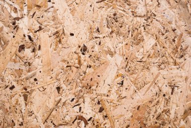 OSB tahtaları ahşap bir zemine zımparalanmış kahverengi odun parçalarından yapılmıştır. OSB ahşap kaplama arka planının üst görüntüsü, sıkı, pürüzsüz yüzey. Oryantasyon Strand Kurulu. Süpürge tahtası. Sterling tahtası. Aspenite