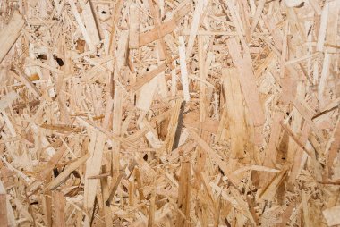 OSB tahtaları ahşap bir zemine zımparalanmış kahverengi odun parçalarından yapılmıştır. OSB ahşap kaplama arka planının üst görüntüsü, sıkı, pürüzsüz yüzey. Oryantasyon Strand Kurulu. Süpürge tahtası. Sterling tahtası. Aspenite