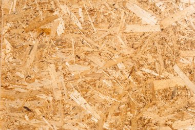 OSB tahtaları ahşap bir zemine zımparalanmış kahverengi odun parçalarından yapılmıştır. OSB ahşap kaplama arka planının üst görüntüsü, sıkı, pürüzsüz yüzey. Oryantasyon Strand Kurulu. Süpürge tahtası. Sterling tahtası. Aspenite