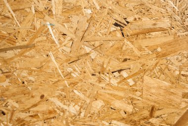 OSB tahtaları ahşap bir zemine zımparalanmış kahverengi odun parçalarından yapılmıştır. OSB ahşap kaplama arka planının üst görüntüsü, sıkı, pürüzsüz yüzey. Oryantasyon Strand Kurulu. Süpürge tahtası. Sterling tahtası. Aspenite