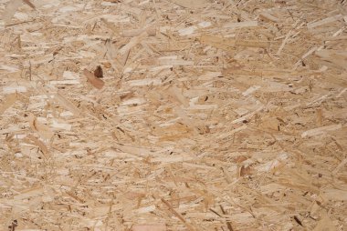 OSB tahtaları ahşap bir zemine zımparalanmış kahverengi odun parçalarından yapılmıştır. OSB ahşap kaplama arka planının üst görüntüsü, sıkı, pürüzsüz yüzey. Oryantasyon Strand Kurulu. Süpürge tahtası. Sterling tahtası. Aspenite