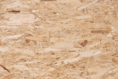 OSB tahtaları ahşap bir zemine zımparalanmış kahverengi odun parçalarından yapılmıştır. OSB ahşap kaplama arka planının üst görüntüsü, sıkı, pürüzsüz yüzey. Oryantasyon Strand Kurulu. Süpürge tahtası. Sterling tahtası. Aspenite