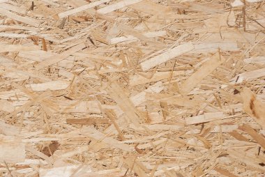 OSB tahtaları ahşap bir zemine zımparalanmış kahverengi odun parçalarından yapılmıştır. OSB ahşap kaplama arka planının üst görüntüsü, sıkı, pürüzsüz yüzey. Oryantasyon Strand Kurulu. Süpürge tahtası. Sterling tahtası. Aspenite