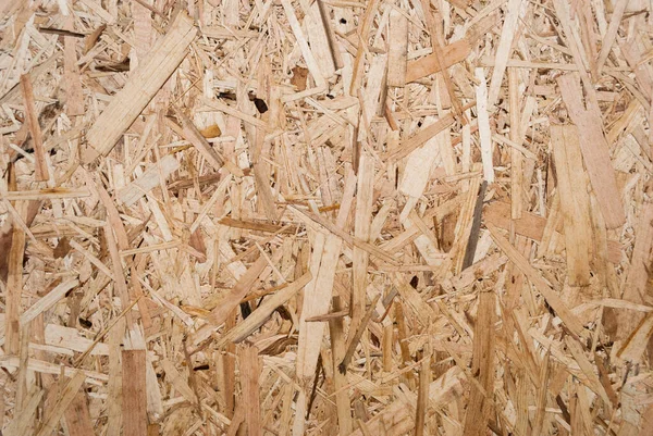 OSB boards are made of brown wood chips sanded into a wooden background. Top view of OSB wood veneer background, tight, seamless surface. Oriented Strand Board. Flake board. Sterling board. Aspenite