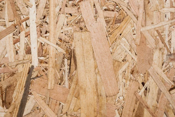 OSB boards are made of brown wood chips sanded into a wooden background. Top view of OSB wood veneer background, tight, seamless surface. Oriented Strand Board. Flake board. Sterling board. Aspenite