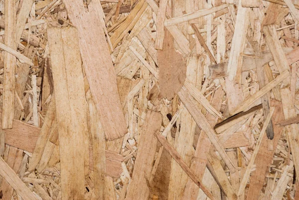 OSB boards are made of brown wood chips sanded into a wooden background. Top view of OSB wood veneer background, tight, seamless surface. Oriented Strand Board. Flake board. Sterling board. Aspenite