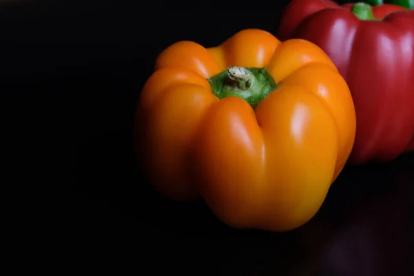 Siyah arkaplanda kırmızı sarı sarı İspanyol biberi