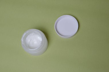 Yeşil arka planda beyaz krema kavanozu