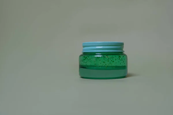 Yeşil arka planda yeşil aloe jeli küçük kavanoz