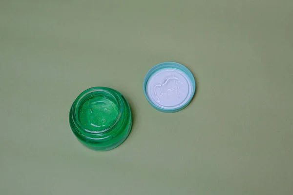 Yeşil arka planda yeşil aloe jeli küçük kavanoz
