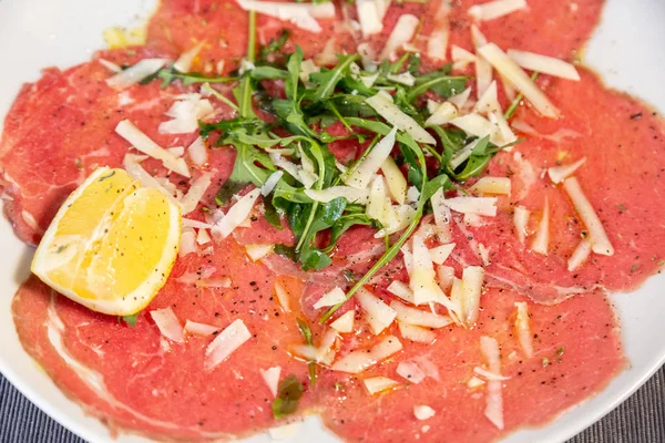 Primo Piano Carne Carpaccio Con Parmigiano Rucola Piatto Bianco Tavolo — Foto Stock