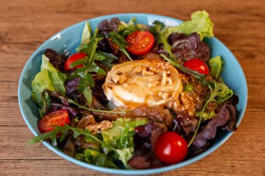 Keçi peyniri, soğan, fıstık, kiraz domates ve salata sosu ile bir salata