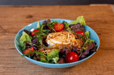 Keçi peyniri, soğan, fıstık, kiraz domates ve salata sosu ile bir salata