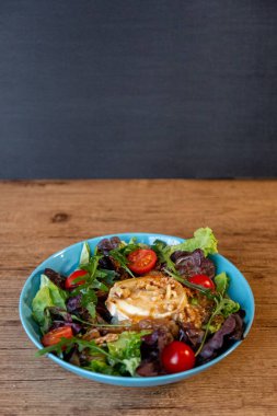 Keçi peyniri, soğan, fıstık, kiraz domates ve salata sosu ile kopya alanı ile bir salata