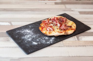 Jambon pizza yemeye hazır un ile ahşap bir masa bir tahtaya üzerinde