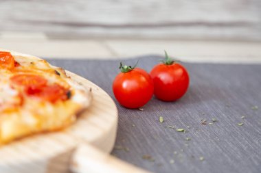 gary masa örtüsü pizza yanında iki kiraz domates ile kekik garnitür