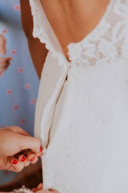 Gelin evlenmeye hazırlanıyor. fermuar gelinlik üzerinde kapatmak için yardımcı kadın eli detay