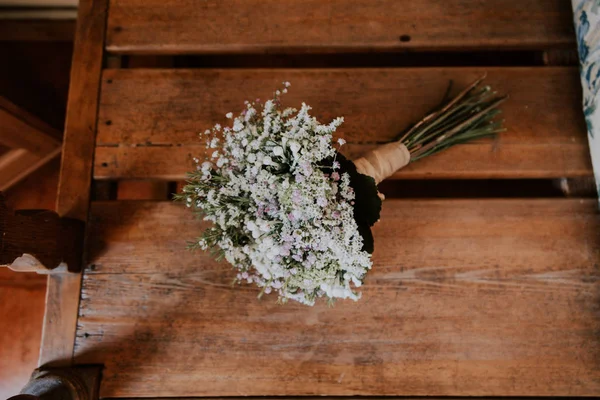 Aerial view of a bridal wedding rustic bouquet on a wooden table