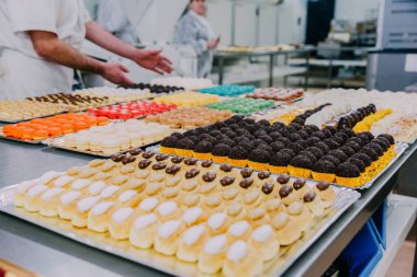 bir gıda fabrikasında işçiler elleriyle metal masa üzerinde hazırlanmış pek çok farklı seçenekler